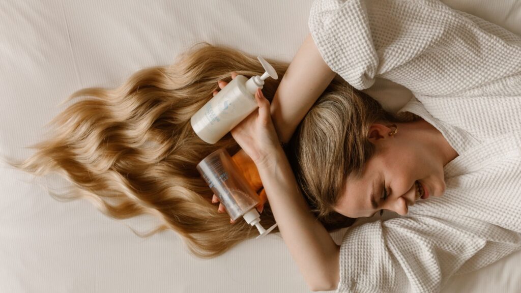 Vrouw met lang haar en een haarverzorgingsflesje