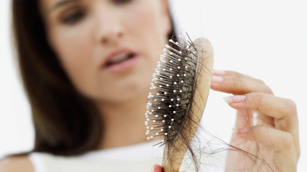Vrouw die een haarborstel met los haar vasthoudt