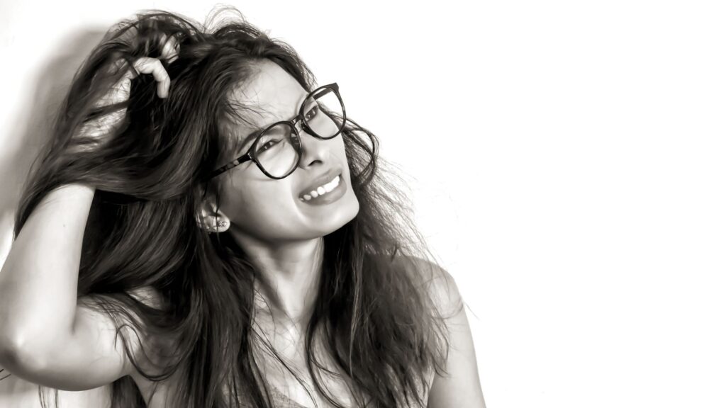 Vrouw die haar hoofd aanraakt terwijl ze in de camera kijkt