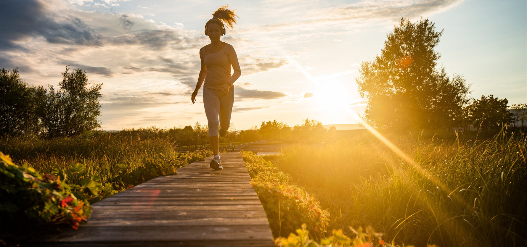 vrouw die hardloopt op een hoeten wandelpad in de natuur
