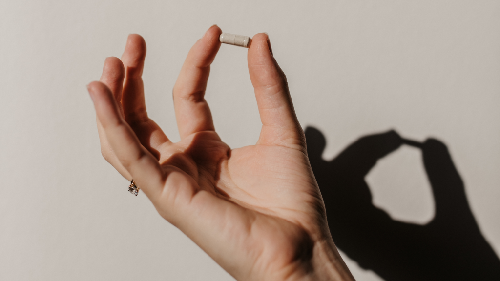 Hand die een transparante capsule vasthoud