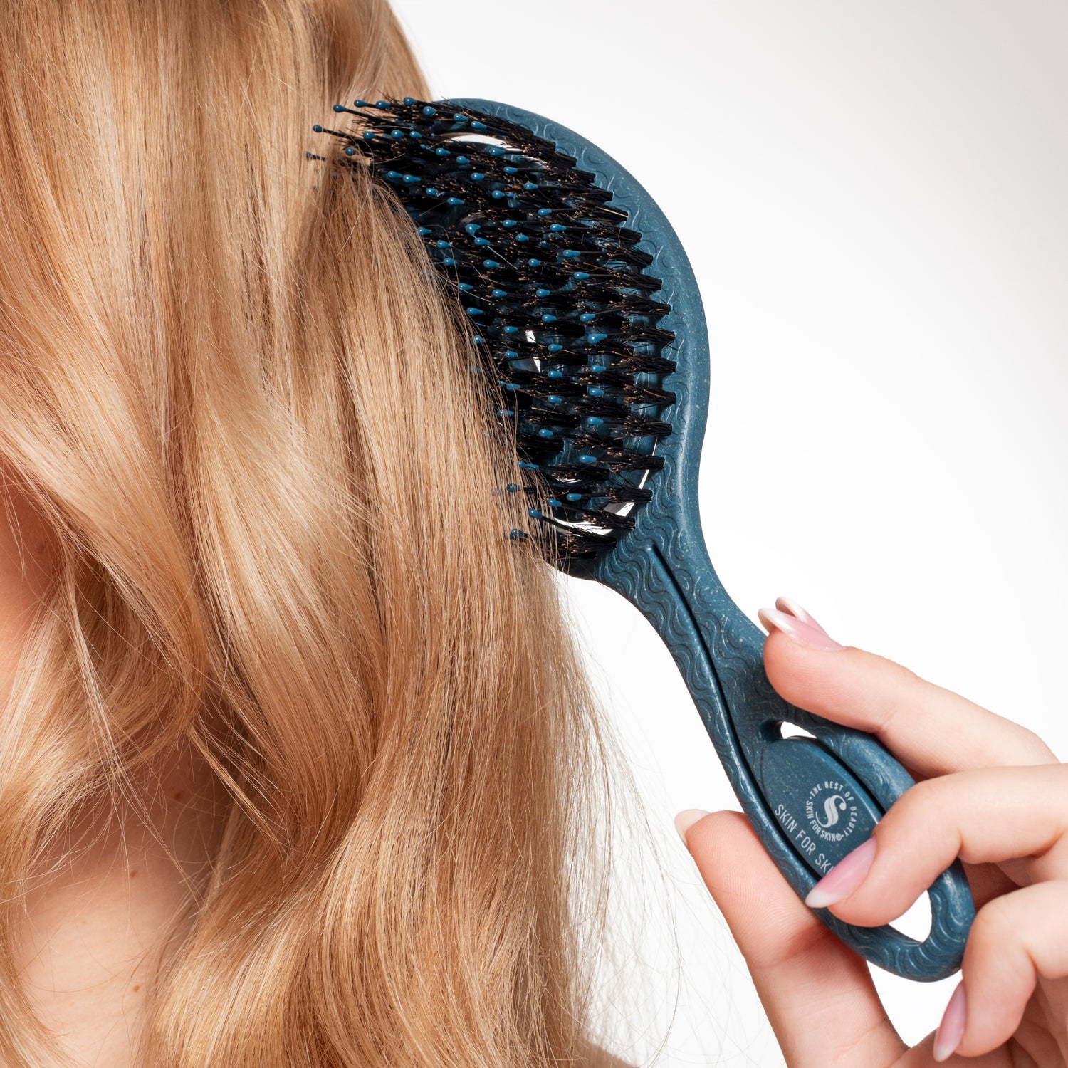 Haar wordt ontward met de Skin for Skin borstel voor een gladde, pluisvrije finish.