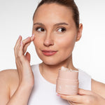 Vrouw brengt Skin for Skin Melt It Down cleansing balm aan en houdt het potje vast.