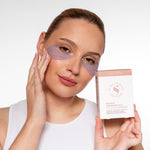 Vrouw draagt Skin for Skin collagen oogpatches en houdt de verpakking vast.