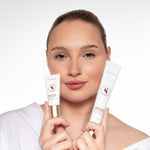 Vrouw houdt twee formaten Skin for Skin Lock It In face base cream vast.